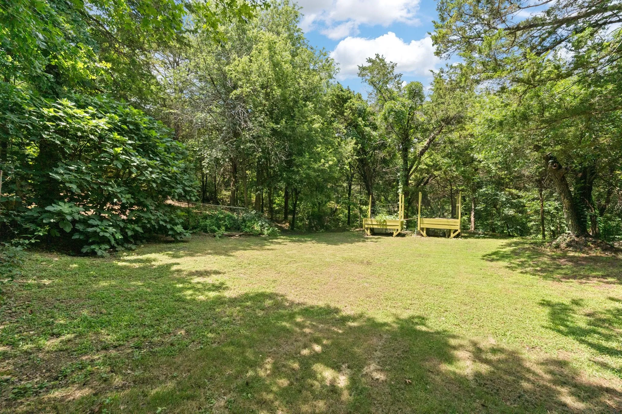 Expansive area on the side of the property with mature perimeter trees, offering natural shade, the possibilities are endless with this large area - expand the already set up raised garden area, future custom pool, play area for the kids, basketball court or even pickleball -