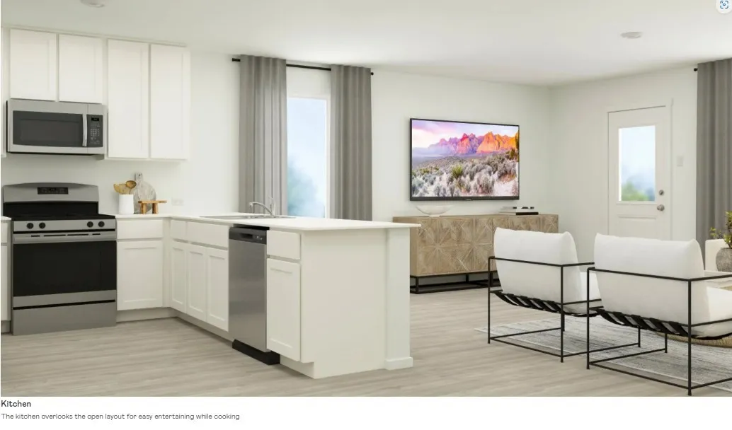 Bright kitchen featuring white cabinetry, stainless steel appliances, and a central island with an integrated sink
