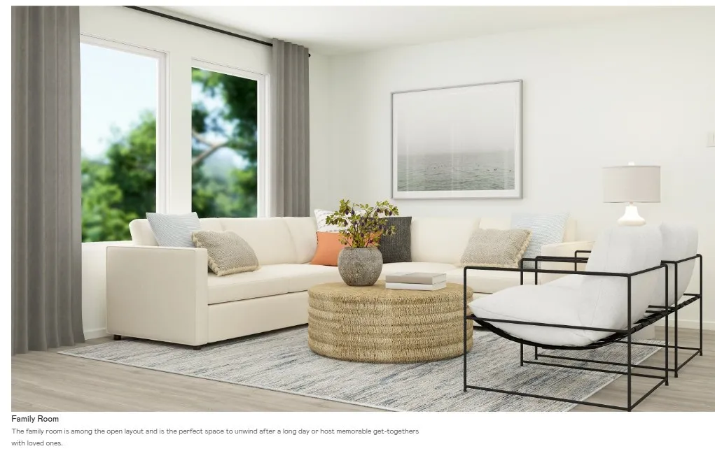 Bright living area featuring wood-finish flooring, a large window with ample natural light, and a white wall finish
