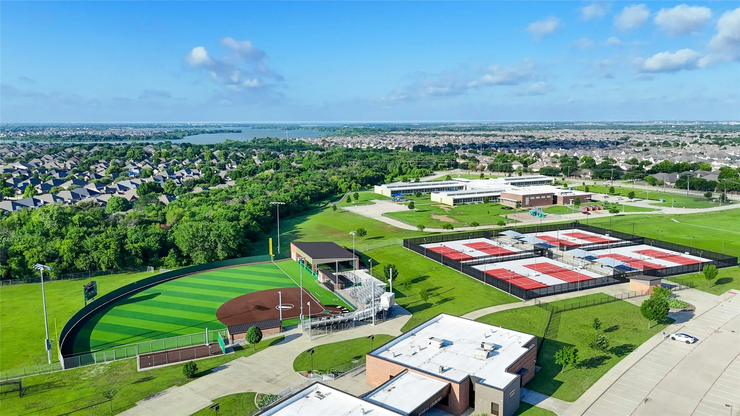 Aerial Perspective Showcasing Baseball Field w Artificial Turf, Multiple Tennis Courts & Several Institutional Buildings.