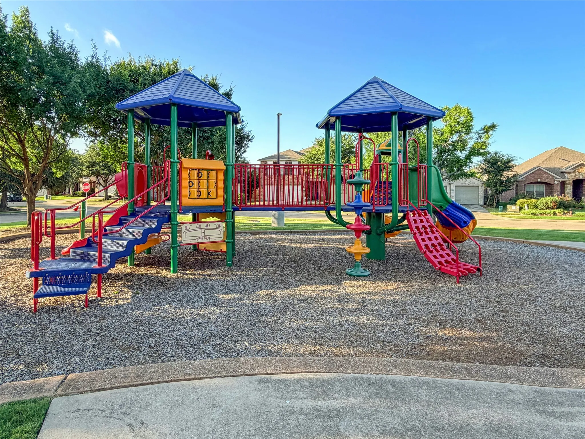 Community Playground Featuring Multi-Level Structure w Slides, Climbing Elements & Protective Ground Cover.