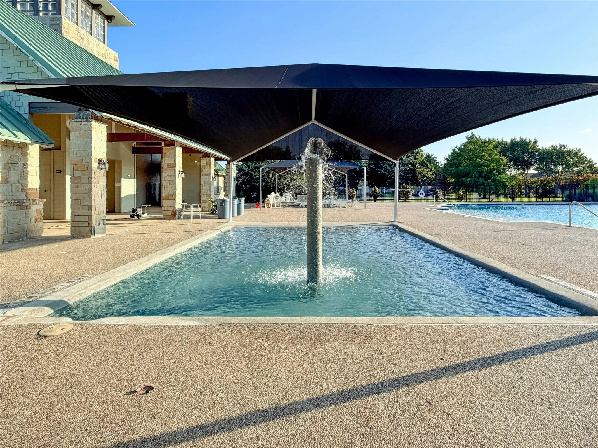 Expansive Aquatic Area Featuring Central Water Feature Under Large Shade Structure.