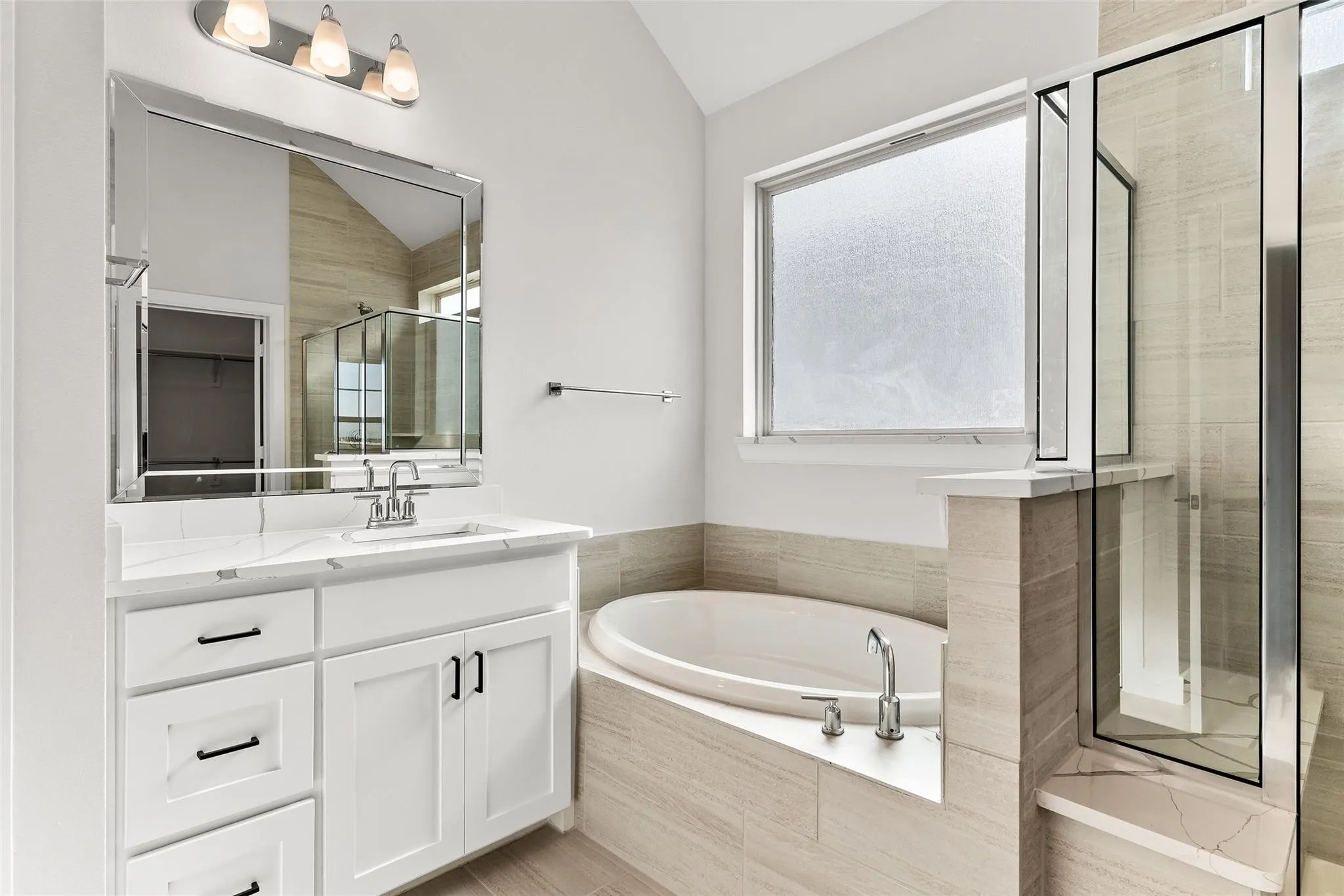 Primary bathroom with dual vanities, separate tub and walk in shower.