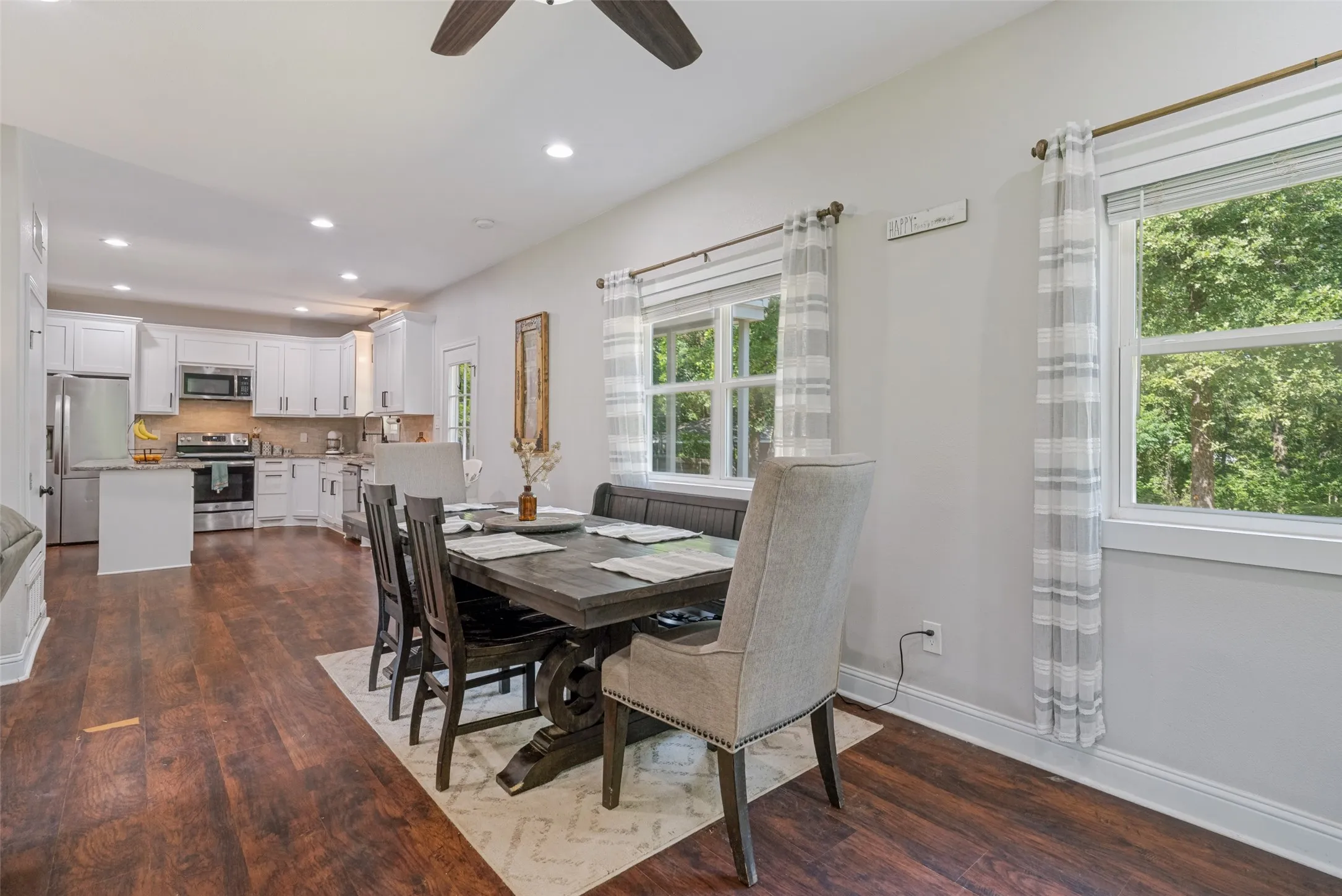 Open-concept dining area featuring wood-finish flooring, recessed lighting, and multiple windows