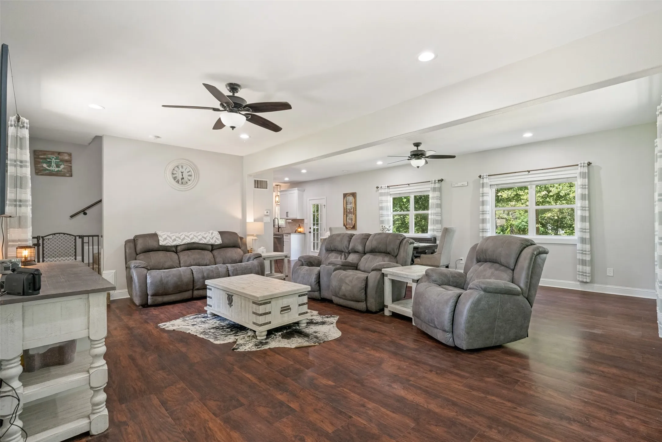 Spacious living area featuring wood-finish flooring, recessed lighting, and dual ceiling fans