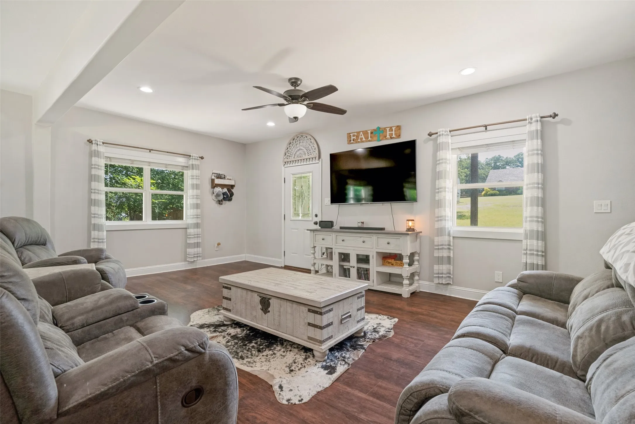 Spacious living area featuring wood-finish flooring, recessed lighting, and a ceiling fan