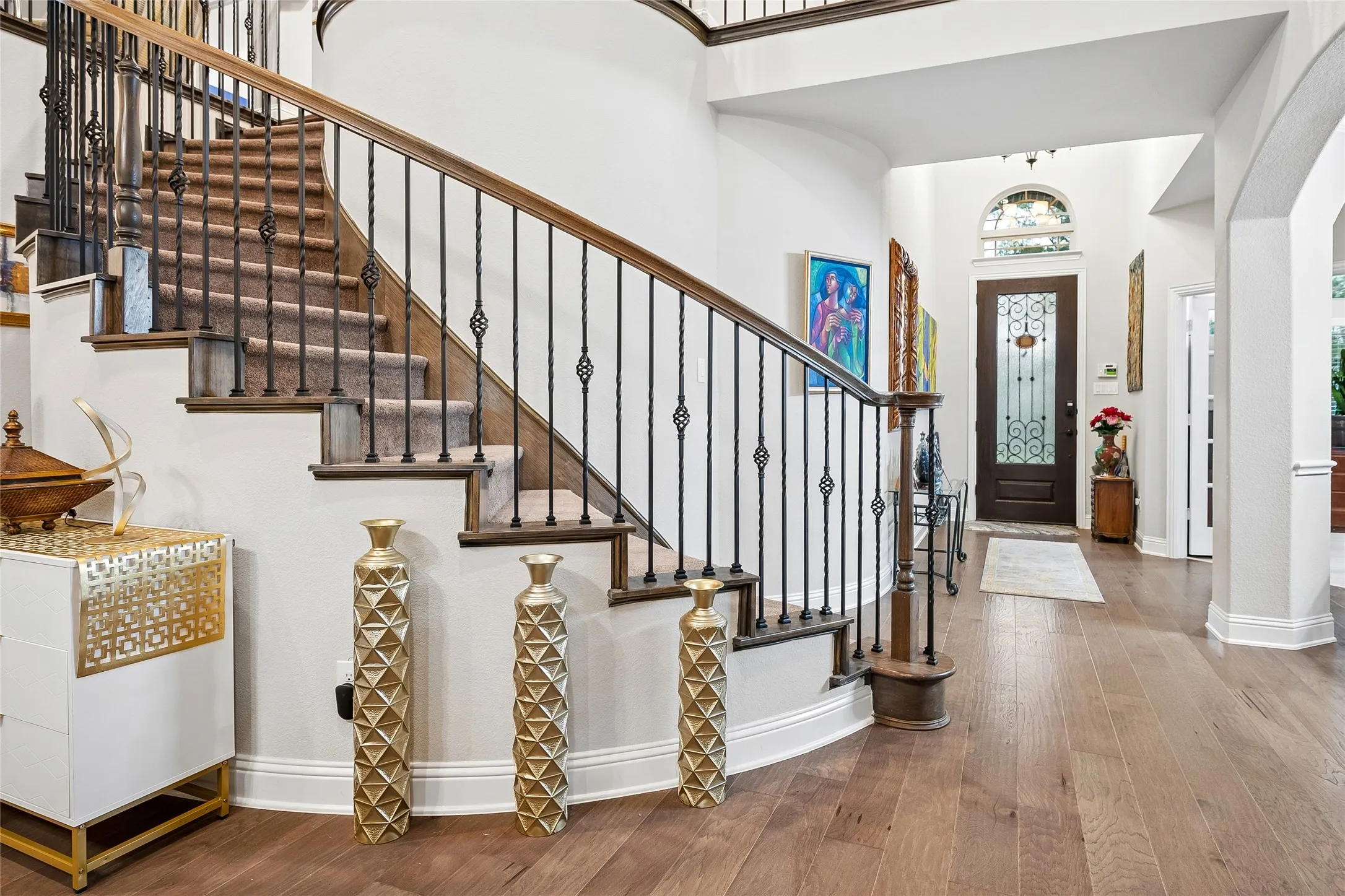 Wood floors, custom front door, sweeping curved staircase
