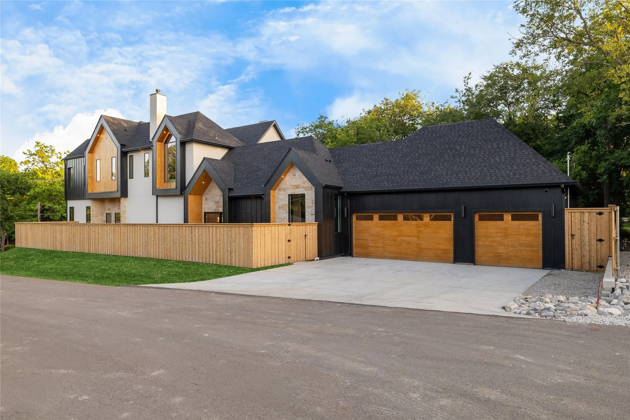 Contemporary exterior featuring a stone and stucco facade with vertical wood accents