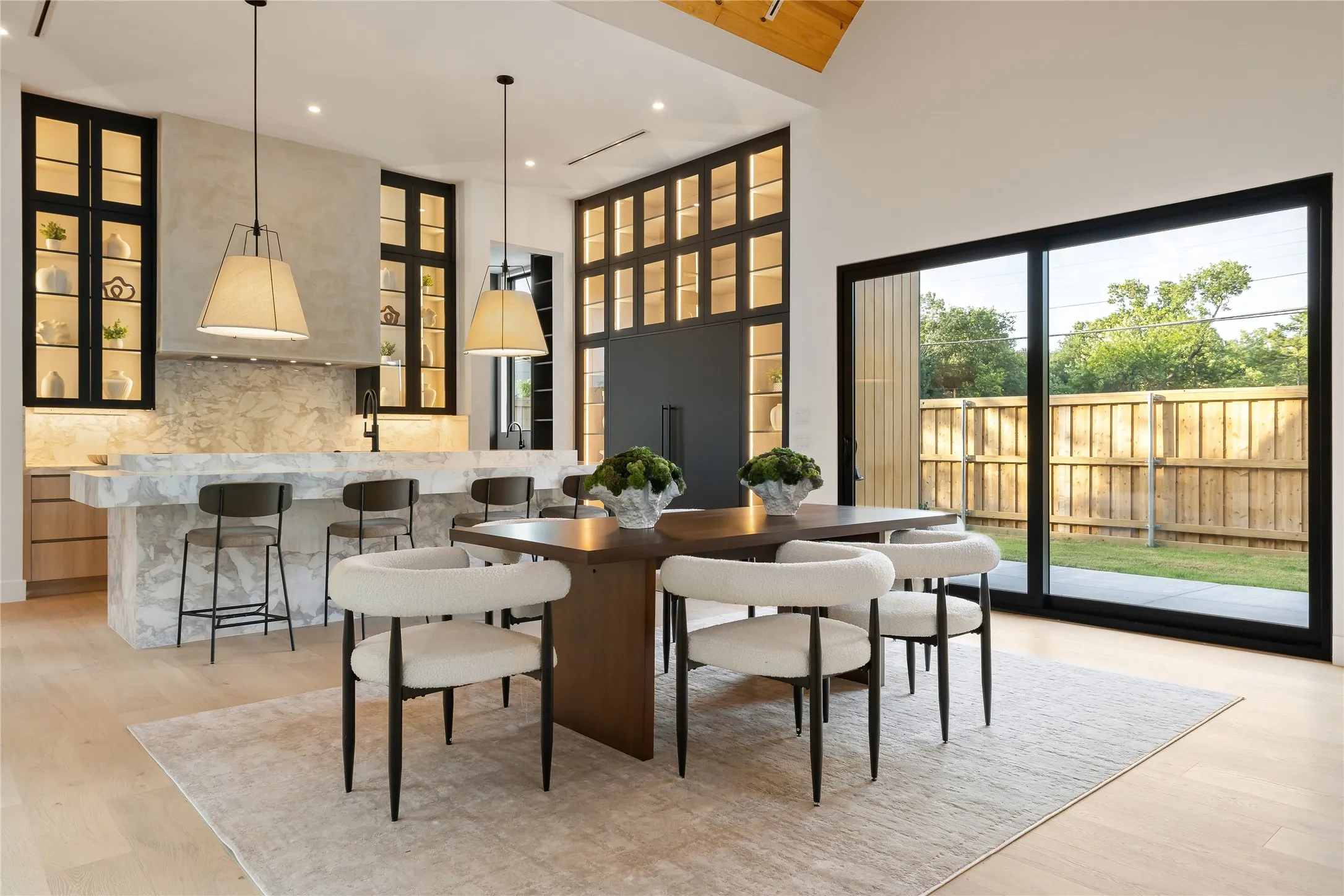 Open-concept living area featuring light wood-finish flooring, a large kitchen island with integrated seating, and a dining space