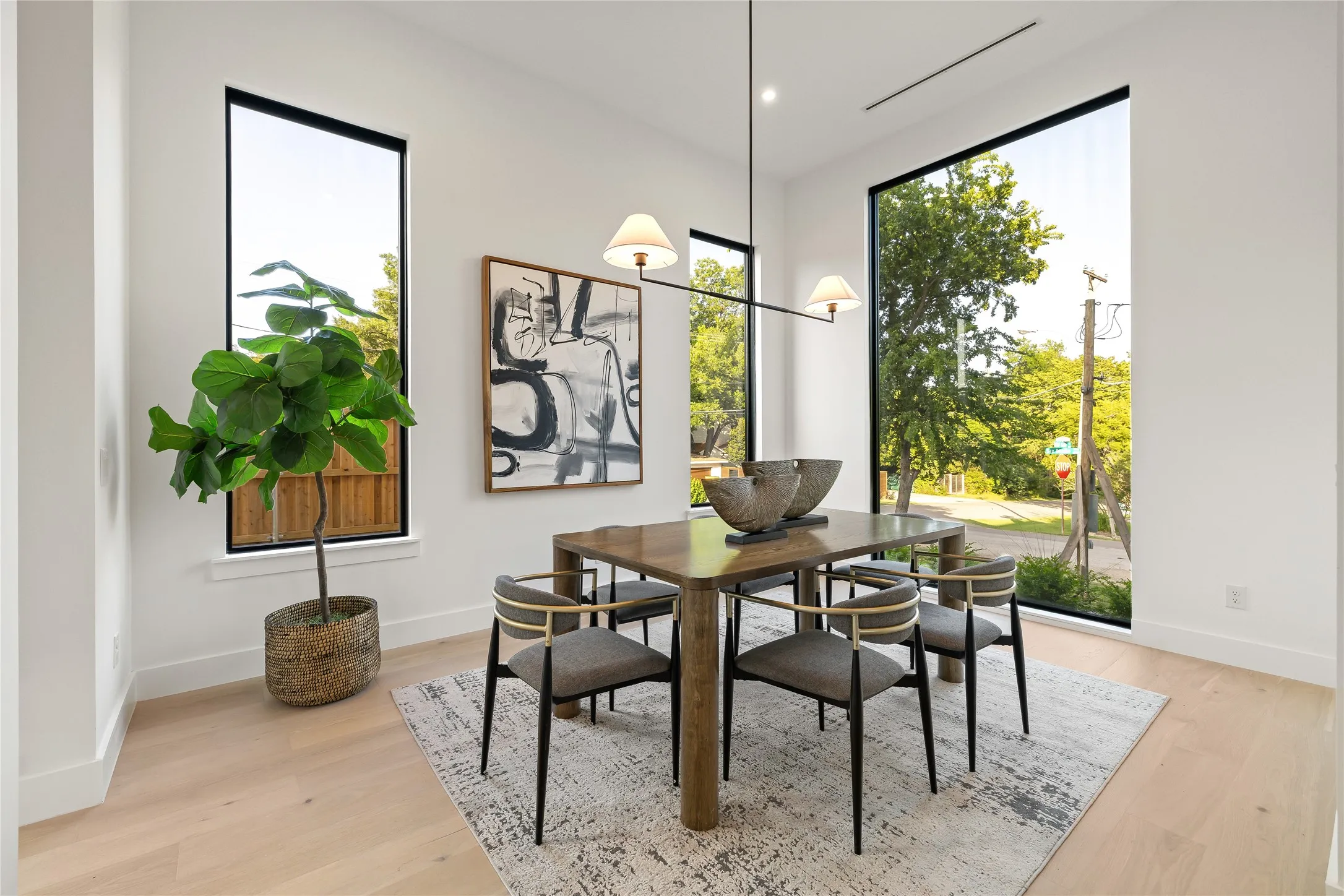 Light wood-finish flooring complements white walls in this dining area