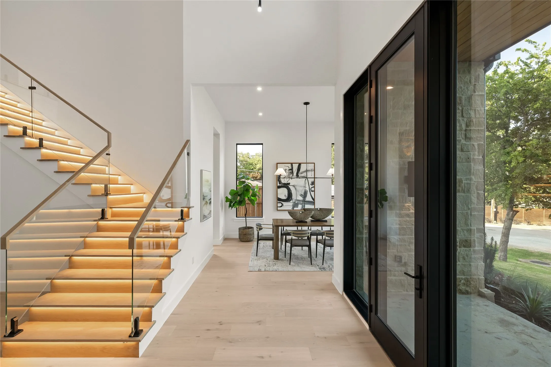 Grand entryway featuring a floating staircase with integrated lighting and glass railing