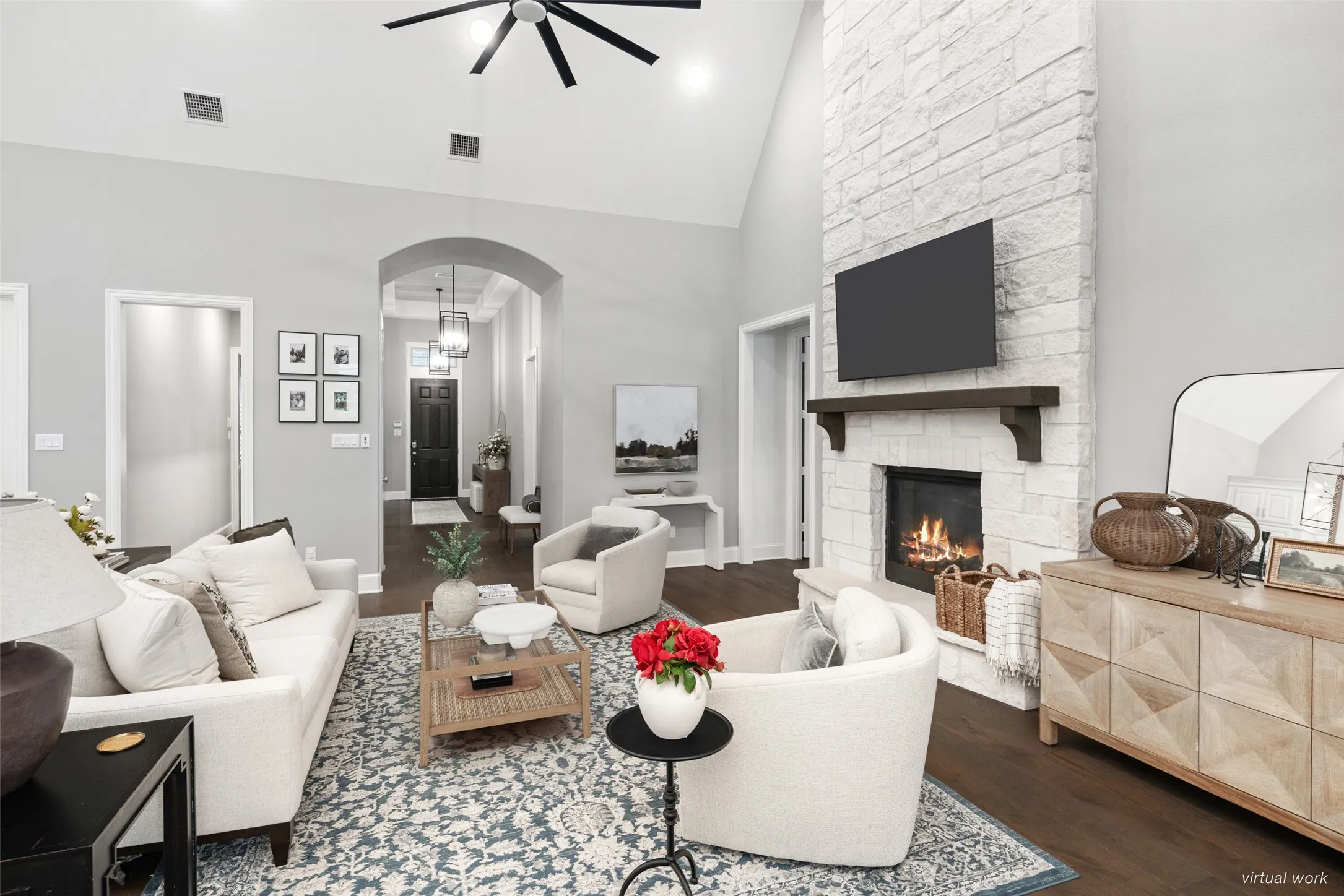 The stunning living room is anchored by a dramatic floor-to-ceiling stone fireplace with a wood mantel, creating a warm yet sophisticated focal point.