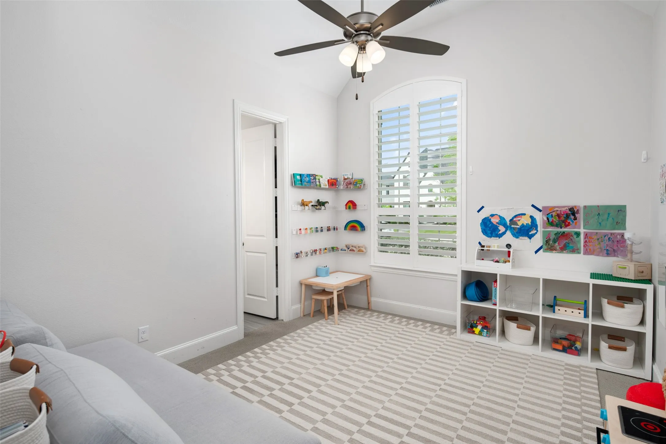 This spacious secondary bedroom offers comfort and privacy with an oversized window adorned with plantation shutters, plush carpeting, and a ceiling fan. Complete with a generous walk-in closet and private ensuite bathroom, this versatile space is ideal for family members, guests, or a growing household.