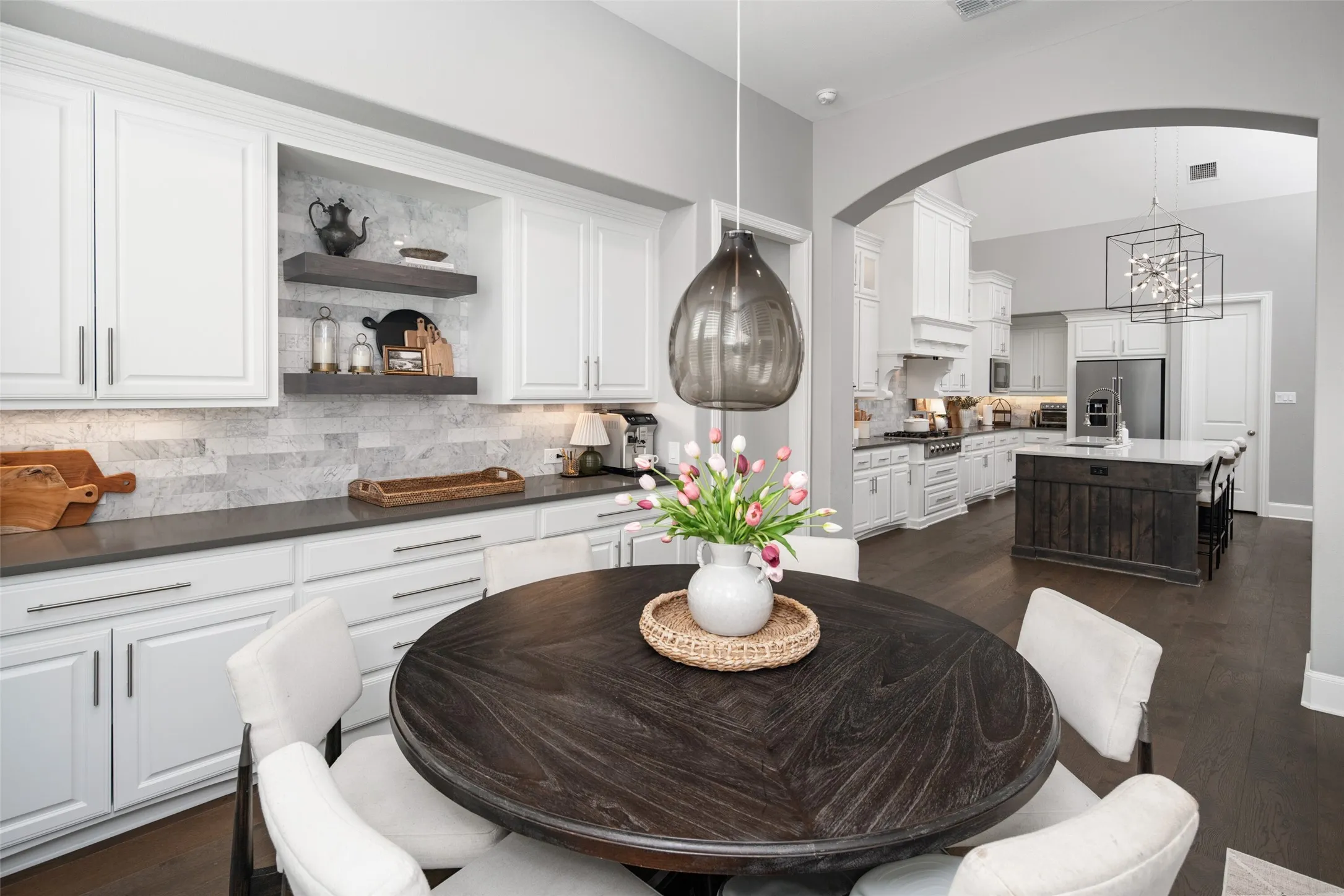 The breakfast nook is enhanced by custom built-in cabinetry and open shelving, providing abundant storage and a stylish serving area that blends everyday functionality with timeless design.