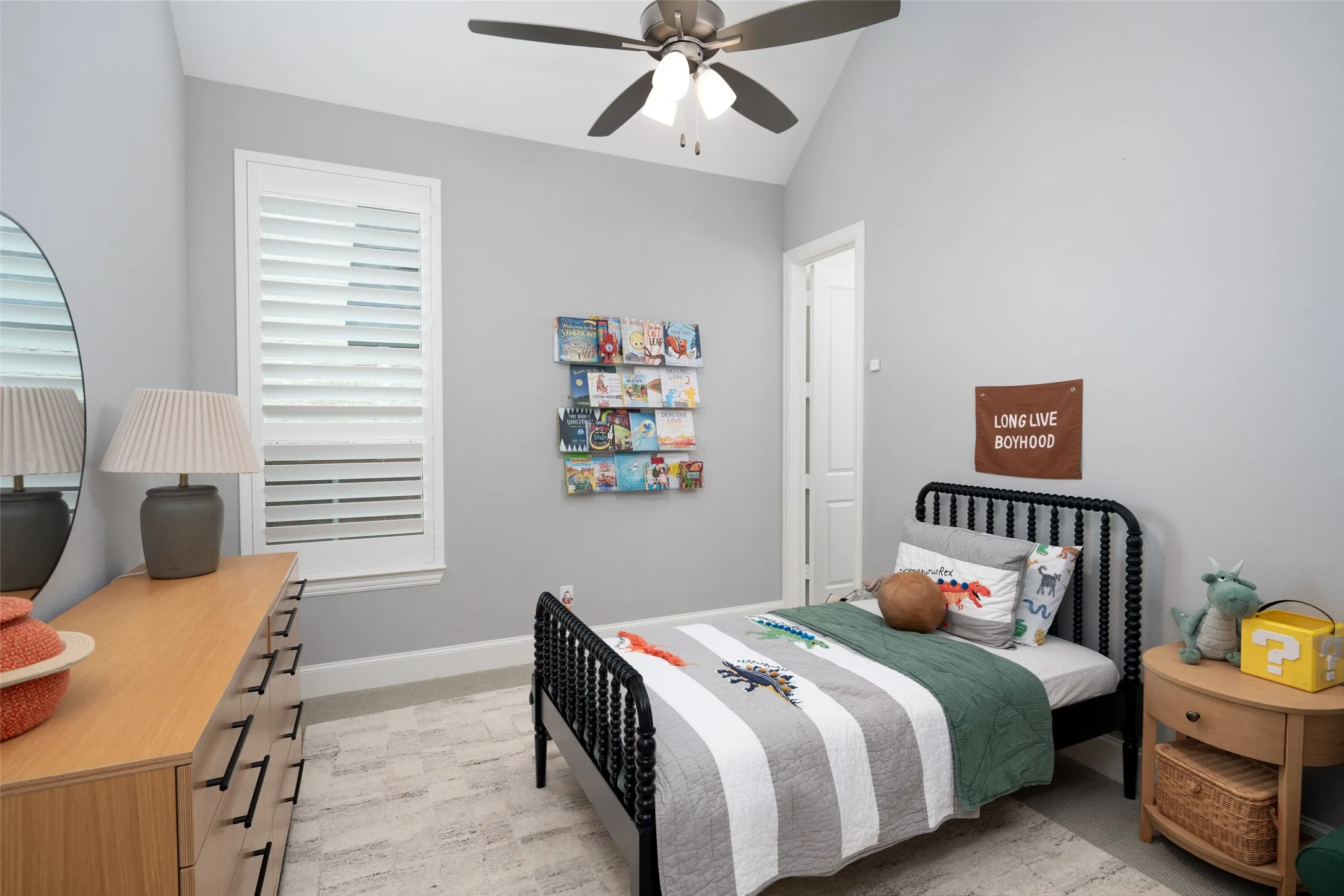 This spacious secondary bedroom features a large window with plantation shutters that fills the room with natural light, plush carpeting, a generous walk-in closet, and a private ensuite bathroom.