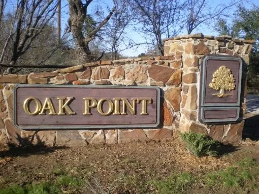 Stone entry monument featuring "Oak Point" signage with a metallic oak tree emblem