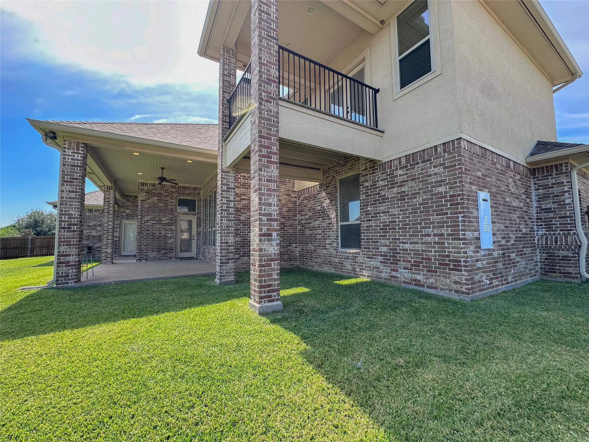 Expansive rear exterior featuring a covered patio with recessed lighting and a ceiling fan