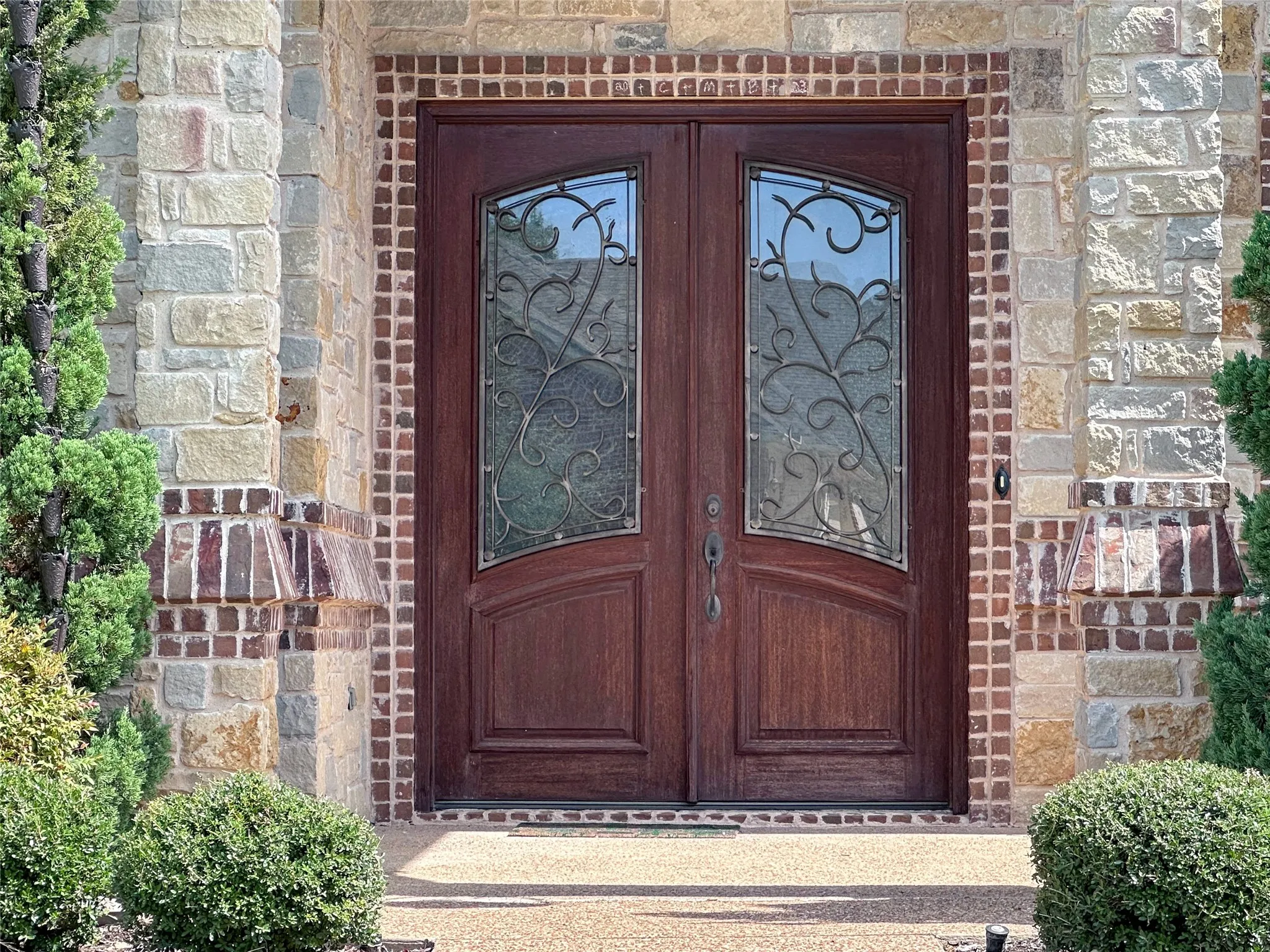 Double-door entry featuring decorative glass inserts with wrought iron detailing