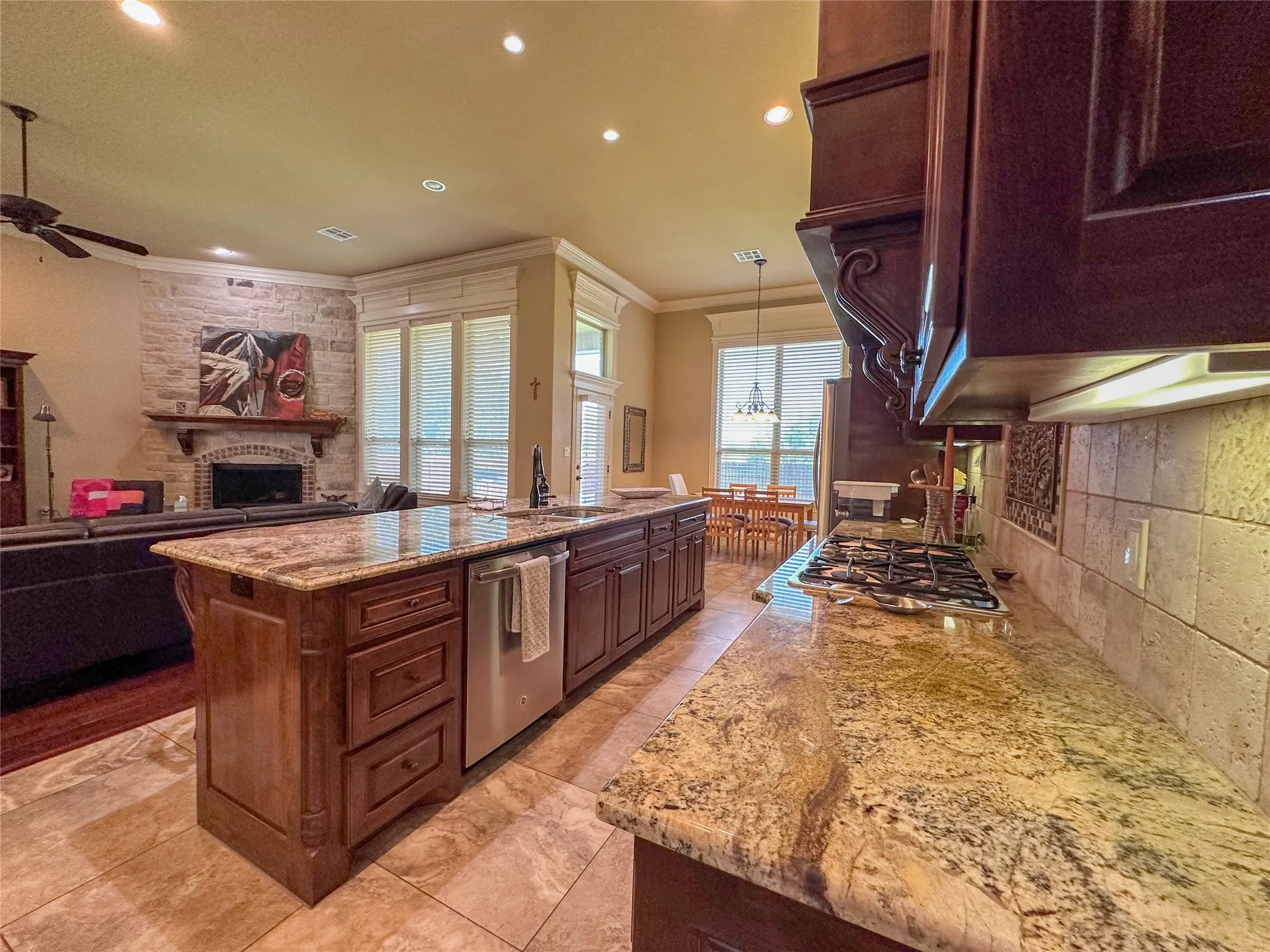 Kitchen featuring granite countertops, wood cabinetry, built-in gas range, and a tiled backsplash