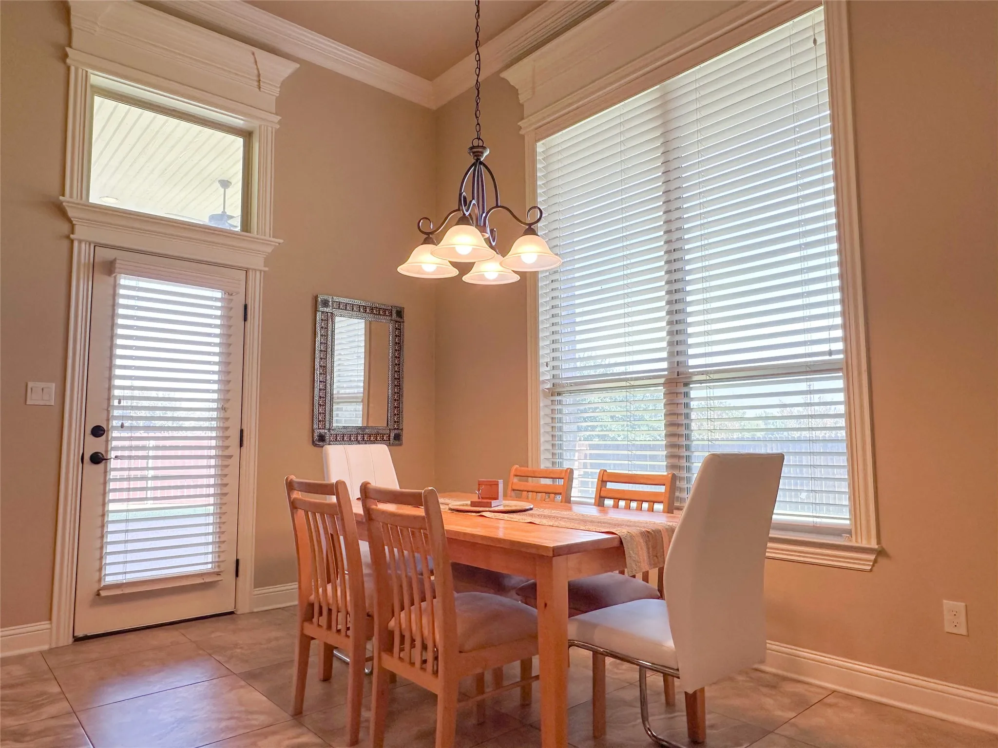 Dining area featuring a high ceiling, crown molding, and tiled flooring
