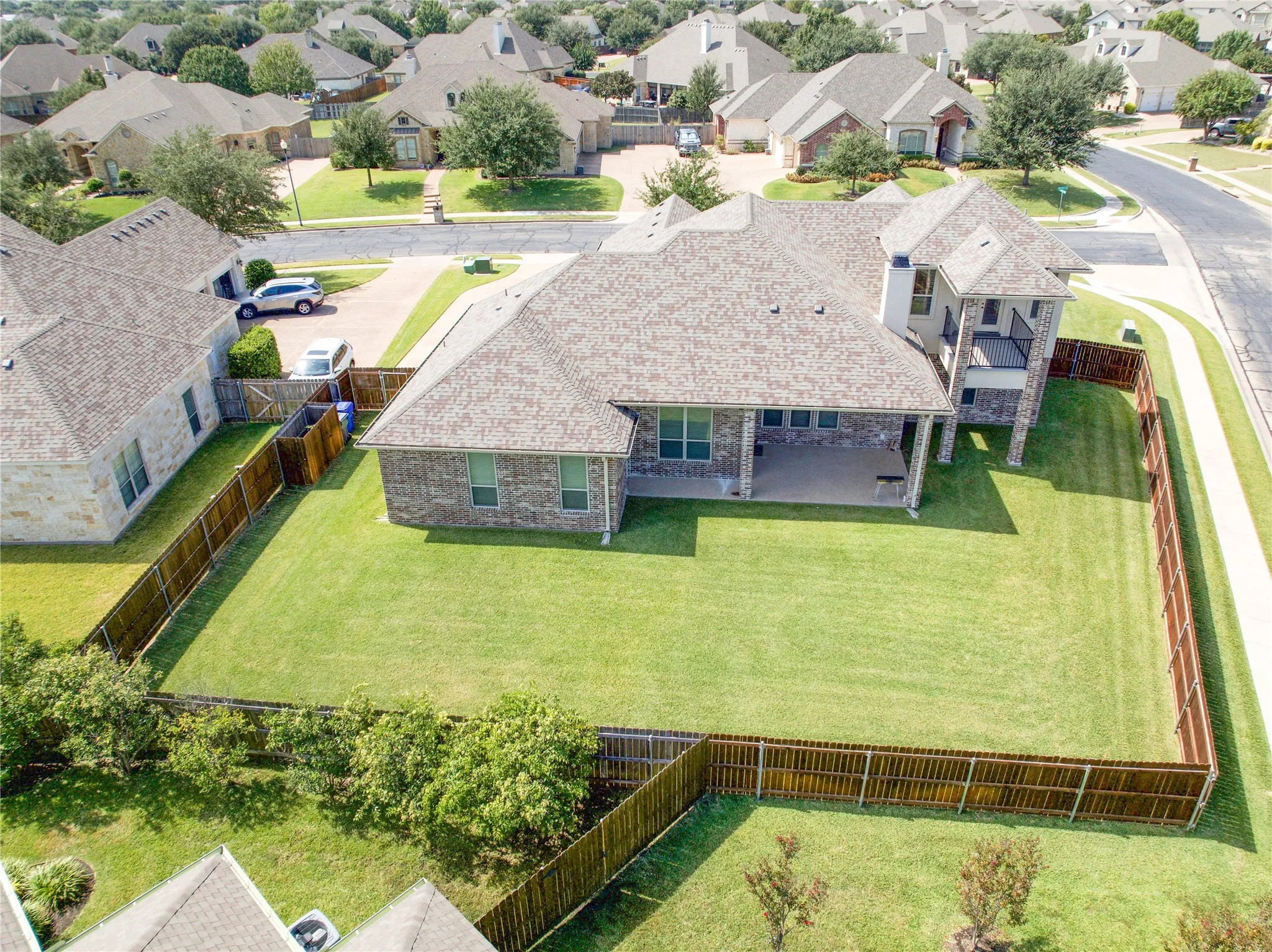 Expansive fenced yard featuring a covered patio