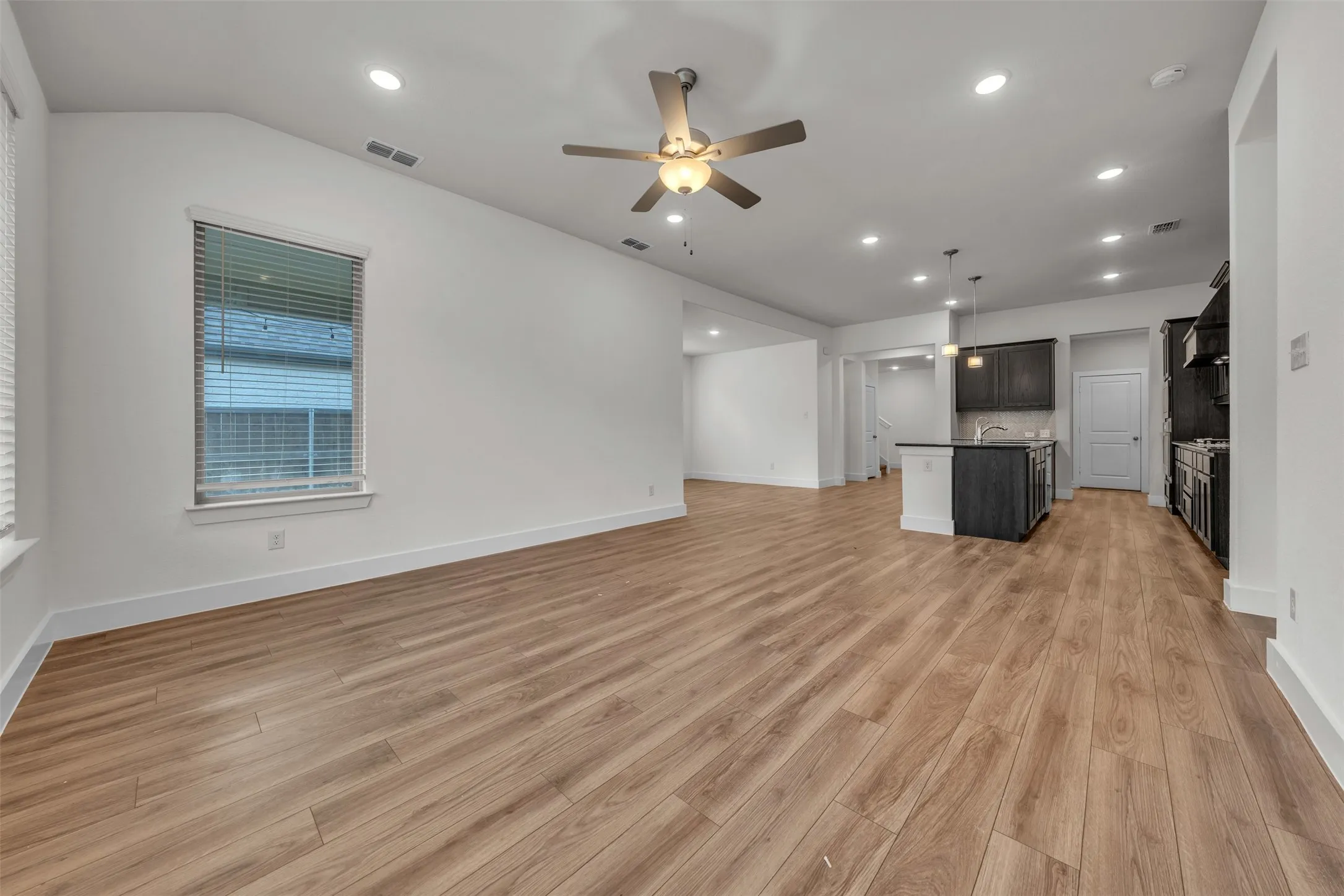 Living Room at 5149 Cantle Ct in Fort Worth, Texas, Tarrant County, with neutral colored LVP. Prewired for TV mount. Celing fan. Open concept to kitchen. Located on first floor.