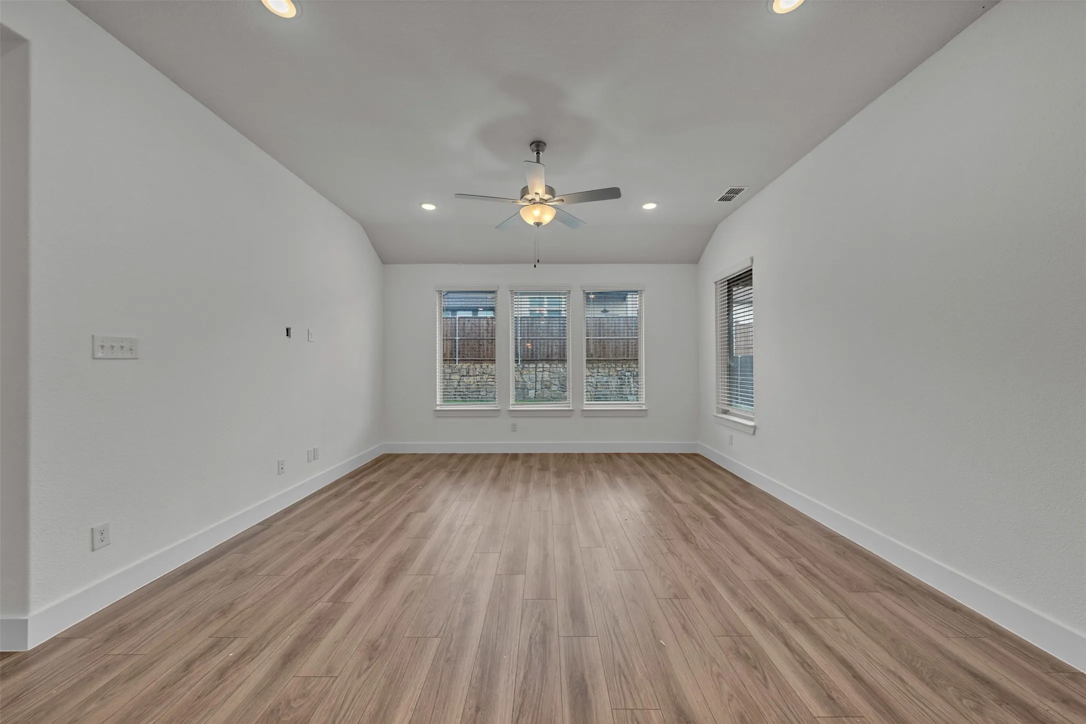 Living Room at 5149 Cantle Ct in Fort Worth, Texas, Tarrant County, with neutral colored LVP. Prewired for TV mount. Celing fan. Open concept to kitchen. Located on first floor.