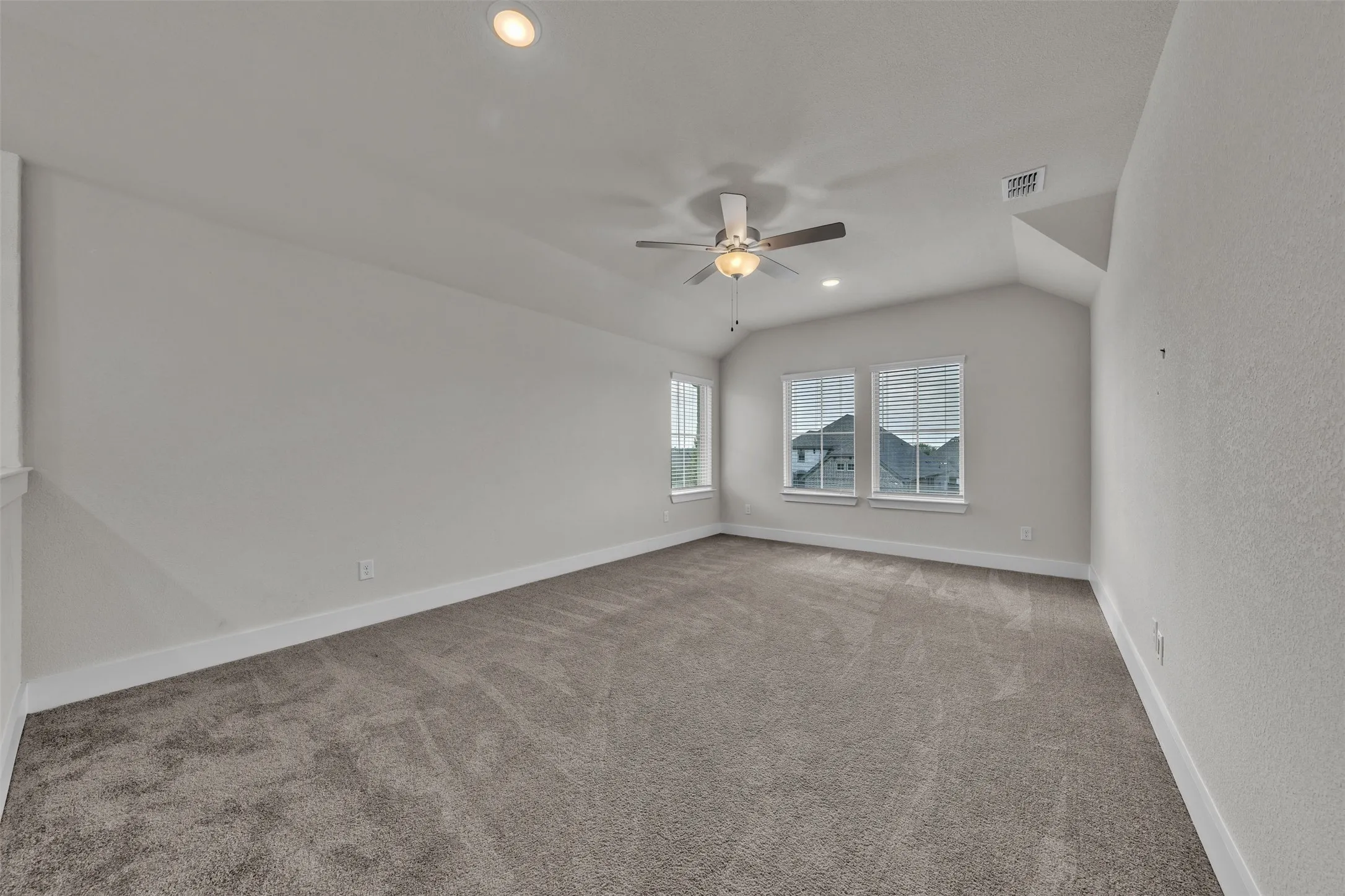 Family Room at 5149 Cantle Ct in Fort Worth, Texas, Tarrant County, with light colored carpet facing large windows allowing natural light. Ceiling fan with dual switch. Located on second floor as a flex space or second living space.