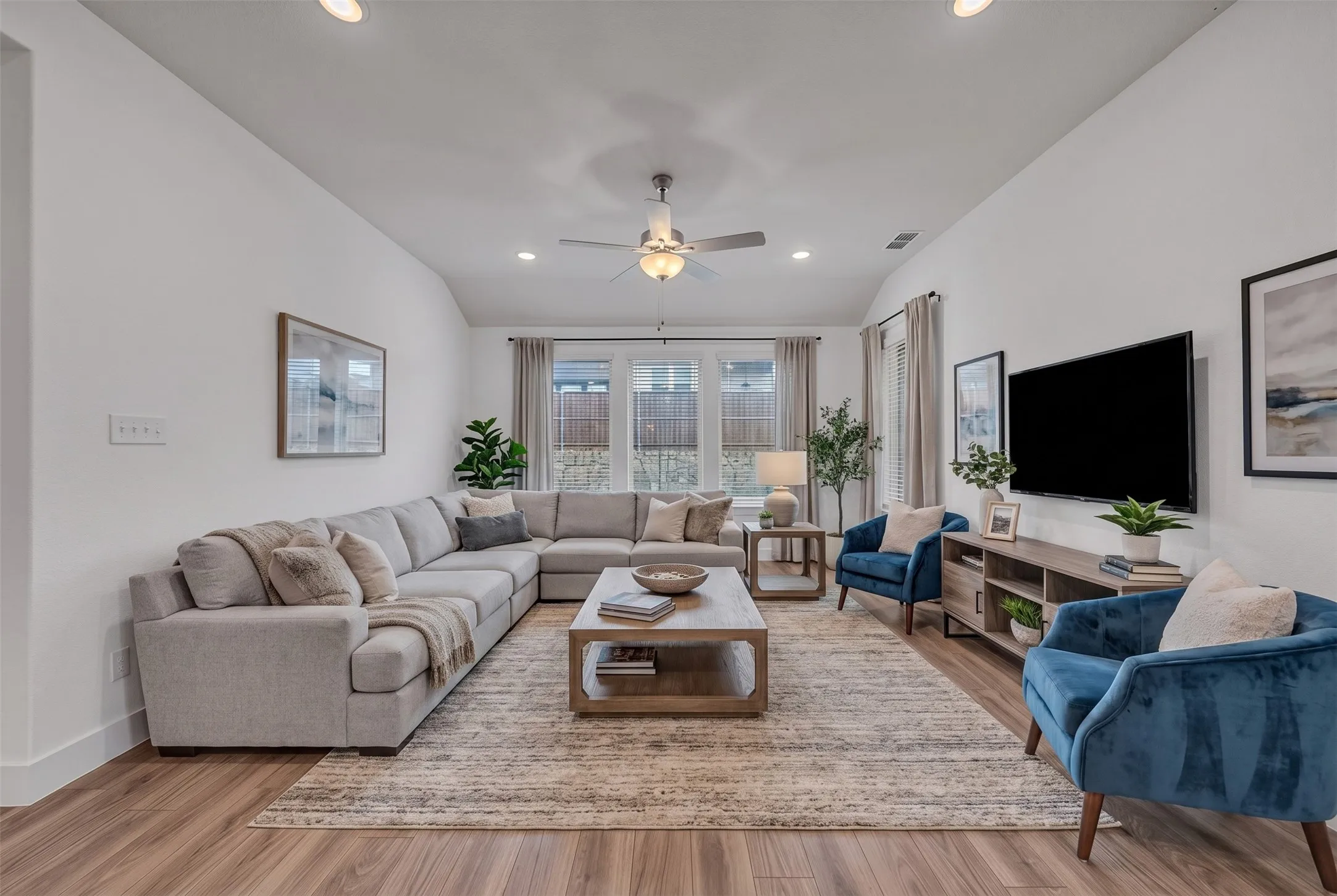 Virtually Staged Living Room at 5149 Cantle Ct in Fort Worth, Texas, Tarrant County, with neutral colored LVP. Prewired for TV mount. Celing fan. Open concept to kitchen. Located on first floor.