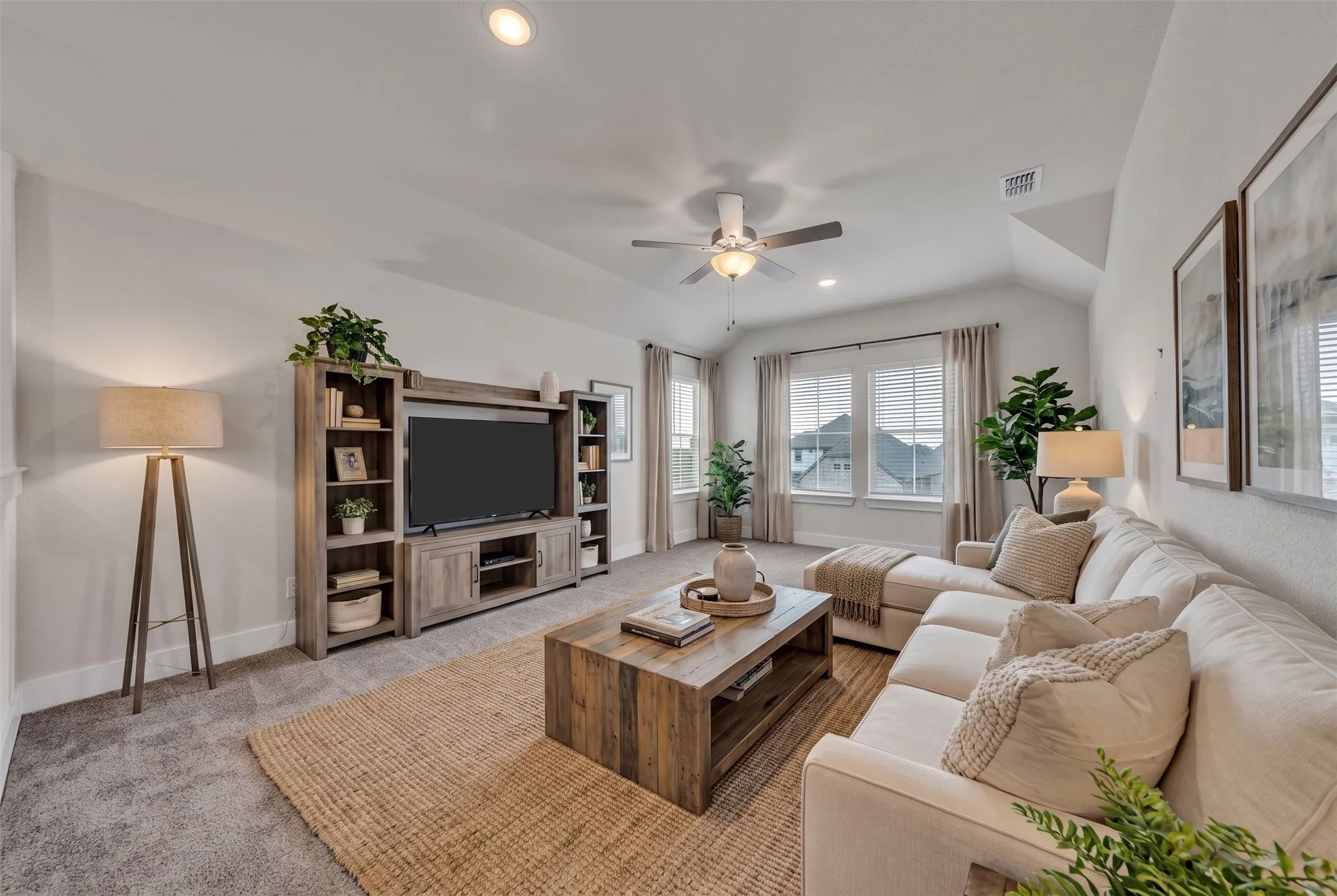Virtually Staged Family Room at 5149 Cantle Ct in Fort Worth, Texas, Tarrant County, with light colored carpet and large windows allowing natural light. Ceiling fan with dual switch. Located on second floor as a flex space or second living space.