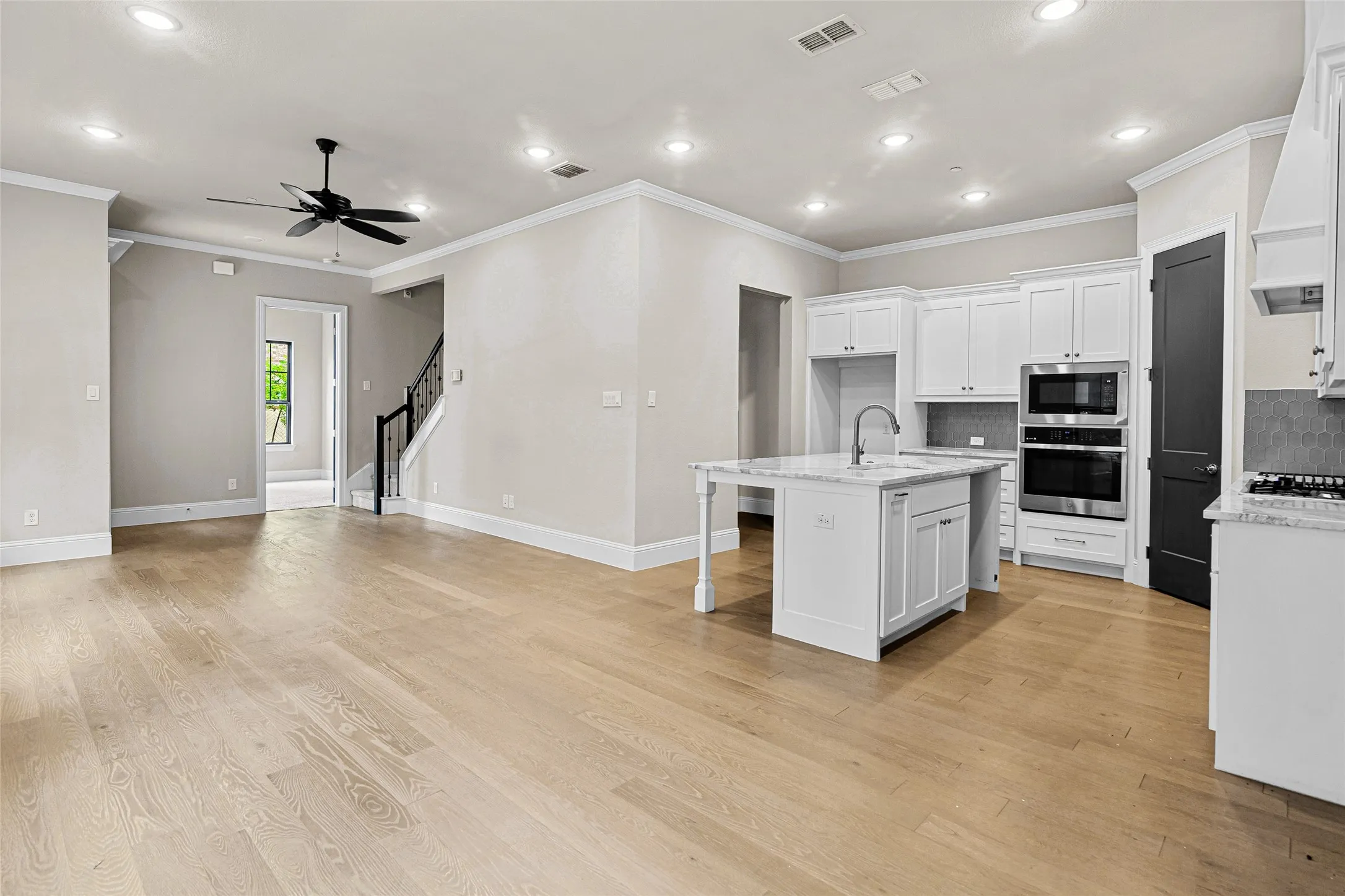 Open-concept living space featuring wood-finish flooring, recessed lighting, and a modern kitchen.
View from the dining area.