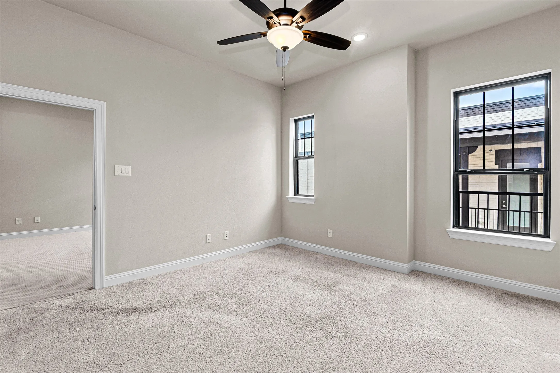 Spacious room featuring neutral carpeting, light-toned wall paint, and white baseboards