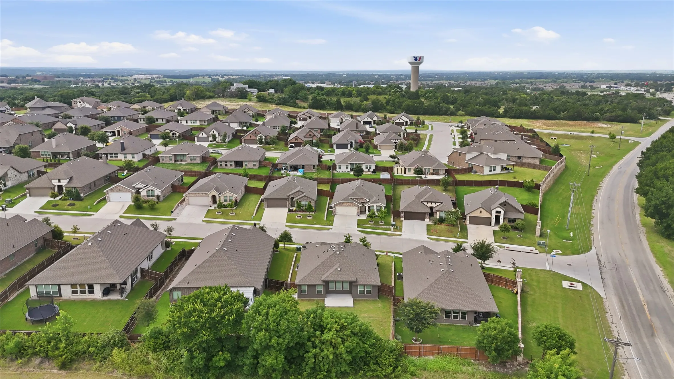 Expansive residential development featuring numerous single-story homes, uniform rooflines, and individual fenced yards