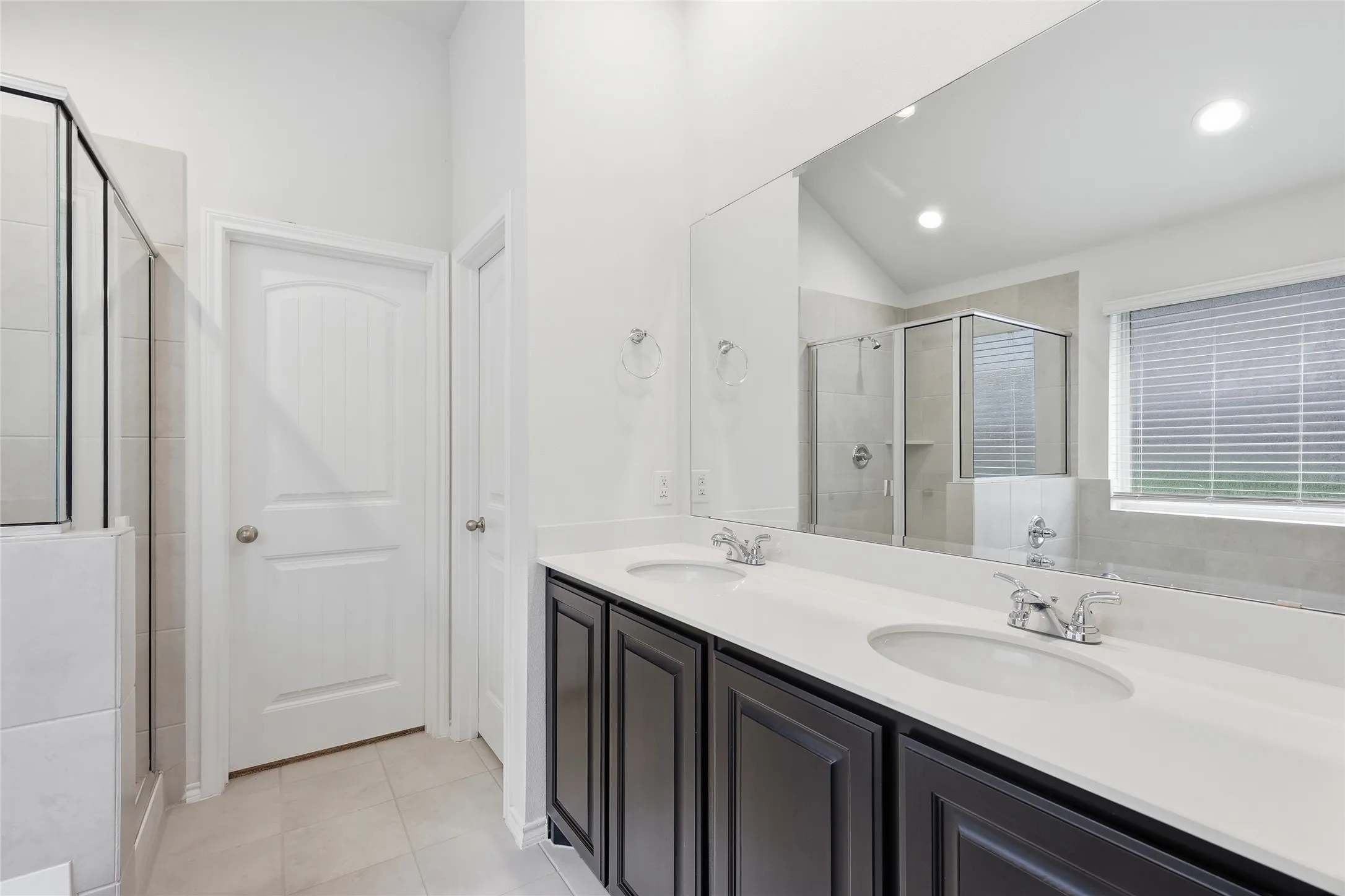 Dual vanity featuring dark cabinetry and white countertops
