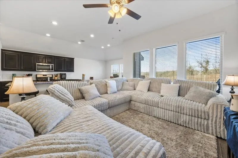 Open-concept living space featuring a spacious layout, recessed lighting, and a ceiling fan