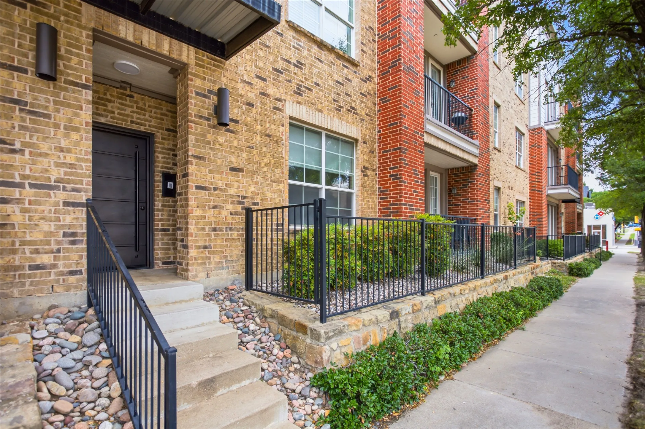 Brick exterior featuring a multi-pane window and concrete entry steps with a black metal handrail