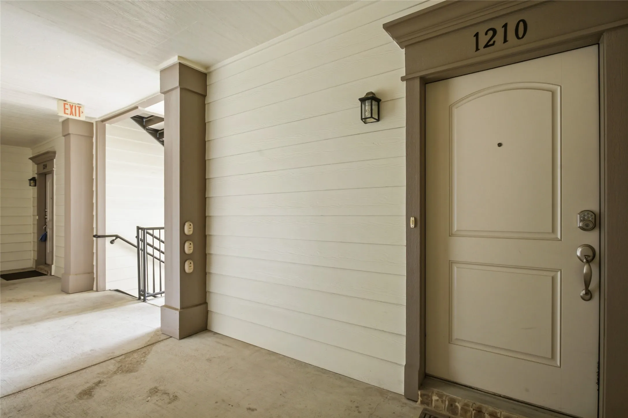 Entryway featuring a panel door with an arched top, brushed nickel hardware, and an overhead address plaque