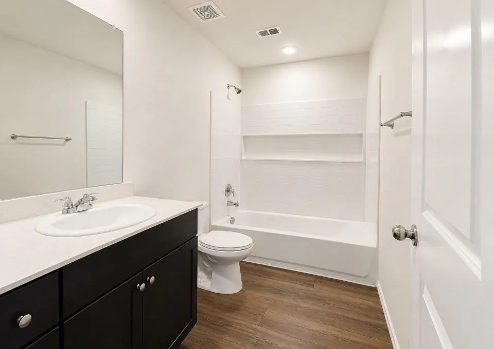 Bathroom featuring a vanity with dark cabinetry and a light countertop, a white oval undermount sink, and a chrome faucet