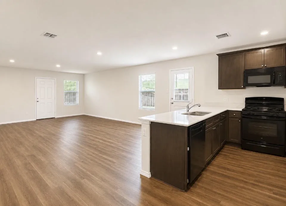 Open concept living space featuring wood-finish flooring, recessed lighting, and a modern kitchen