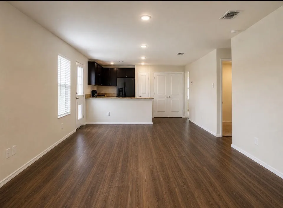 Open-concept living area featuring wood-finish flooring, recessed lighting, and light-toned walls