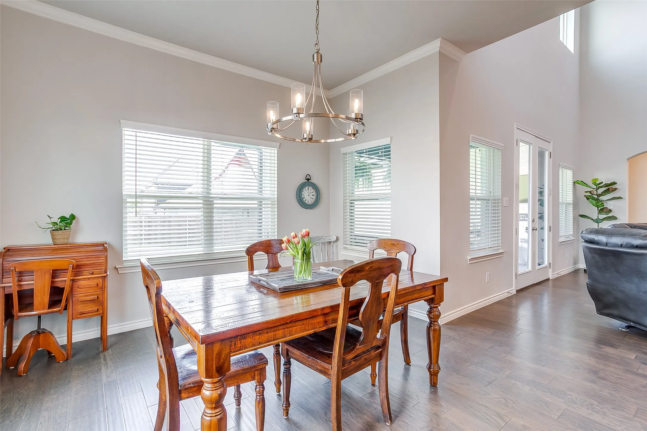 Dining area with wood-finish flooring, a modern chandelier, and multiple windows