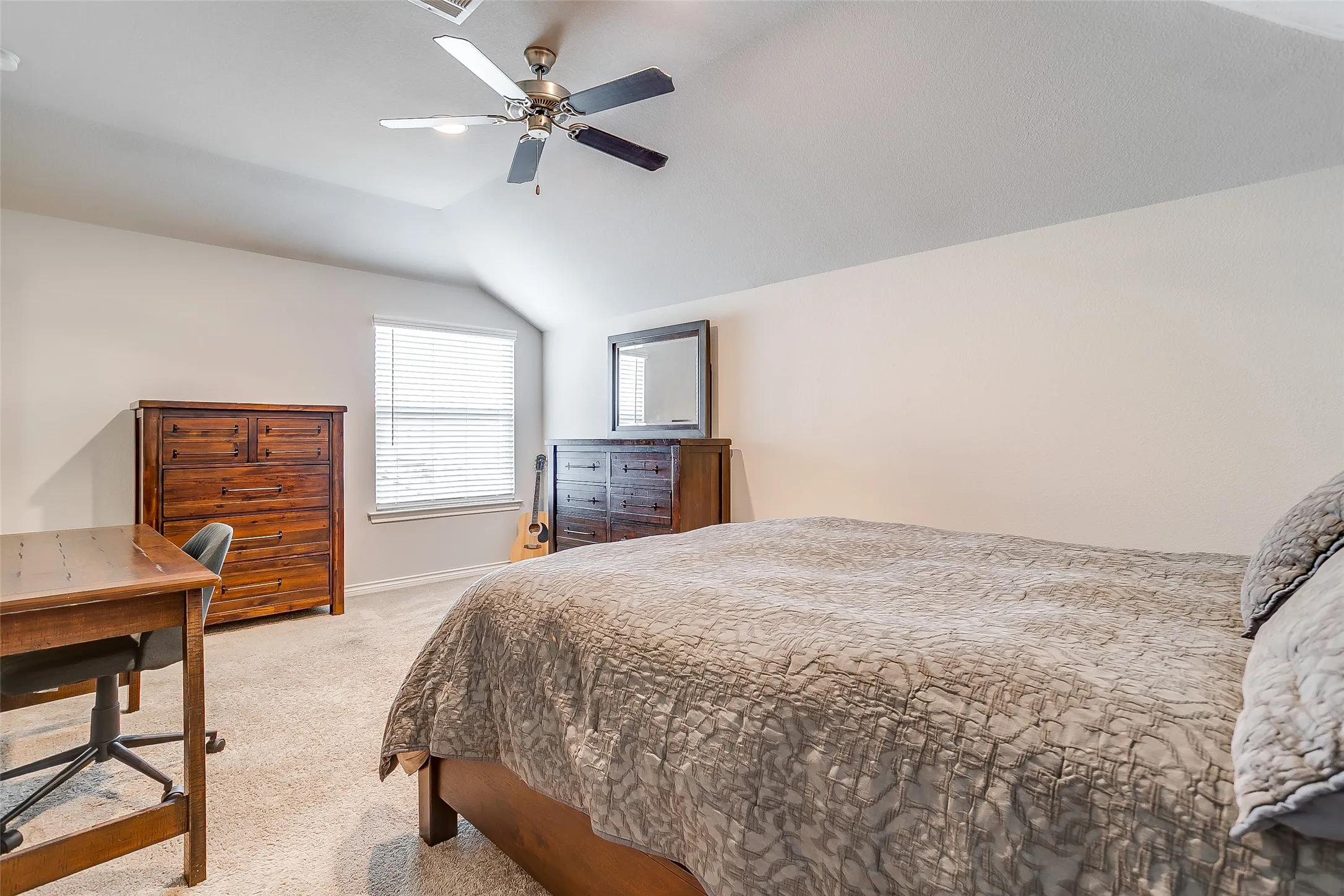 Vaulted ceiling bedroom featuring carpeting, a window with horizontal blinds, and a ceiling fan with integrated lighting