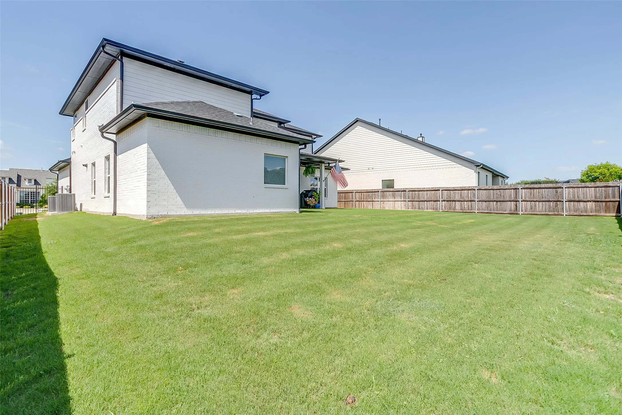 Expansive green lawn with a wood privacy fence