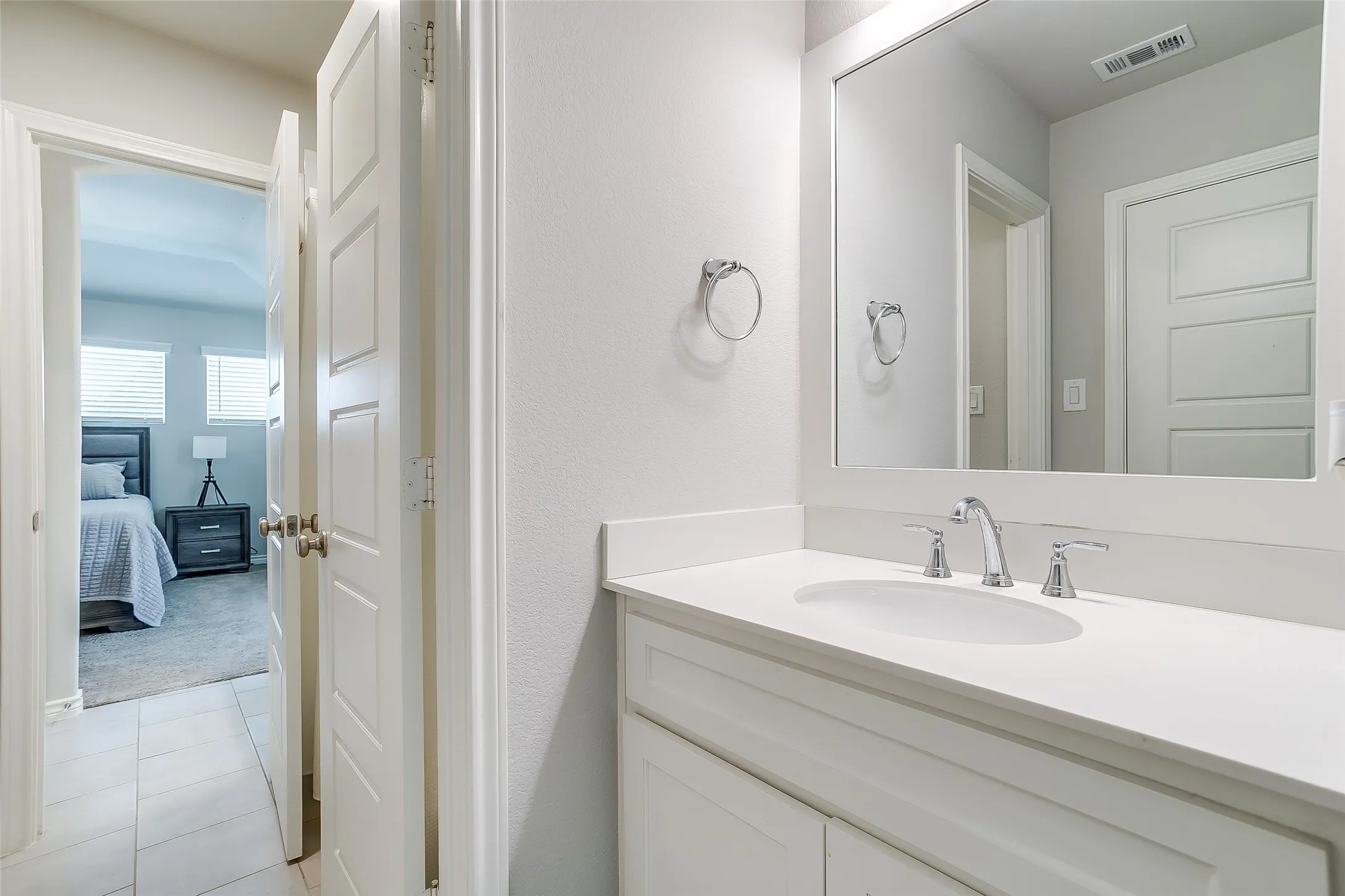 Bathroom vanity featuring a white countertop, undermount sink, and chrome fixtures