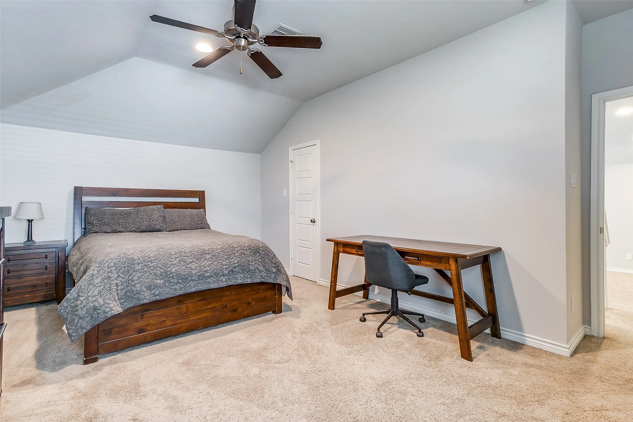 Carpeted room featuring a ceiling fan with integrated lighting, a vaulted ceiling, and white trim