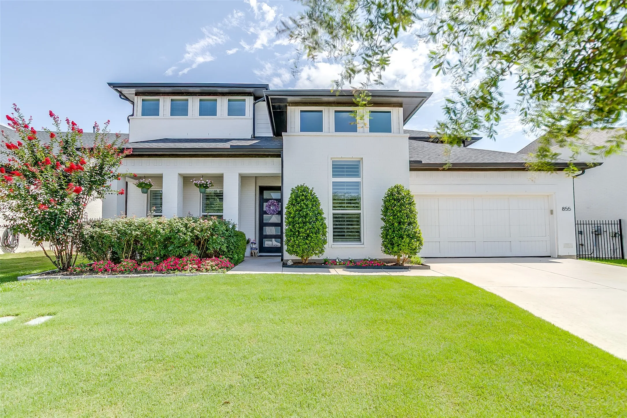 Contemporary white facade featuring dark trim accents and a two-car garage