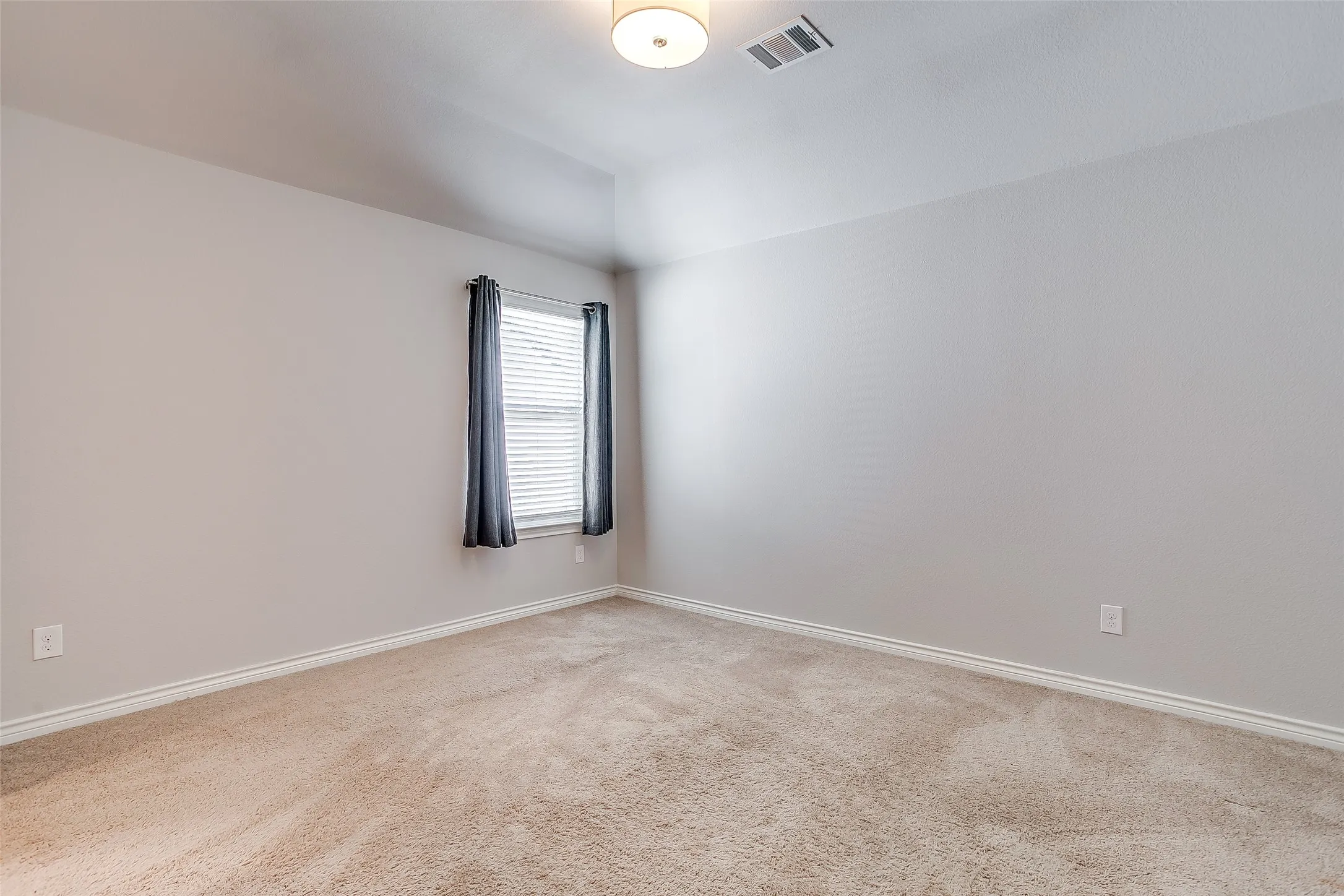 Neutral wall paint, carpeted flooring, window with blinds, recessed ceiling, and a flush mount light fixture