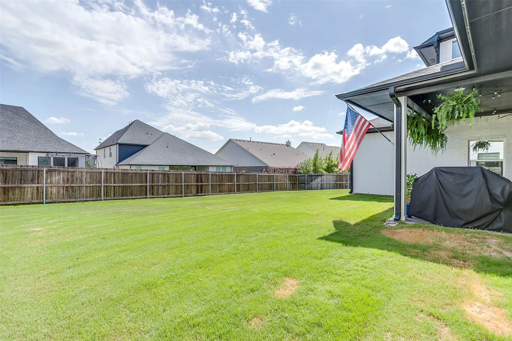 Expansive green lawn with a wood privacy fence