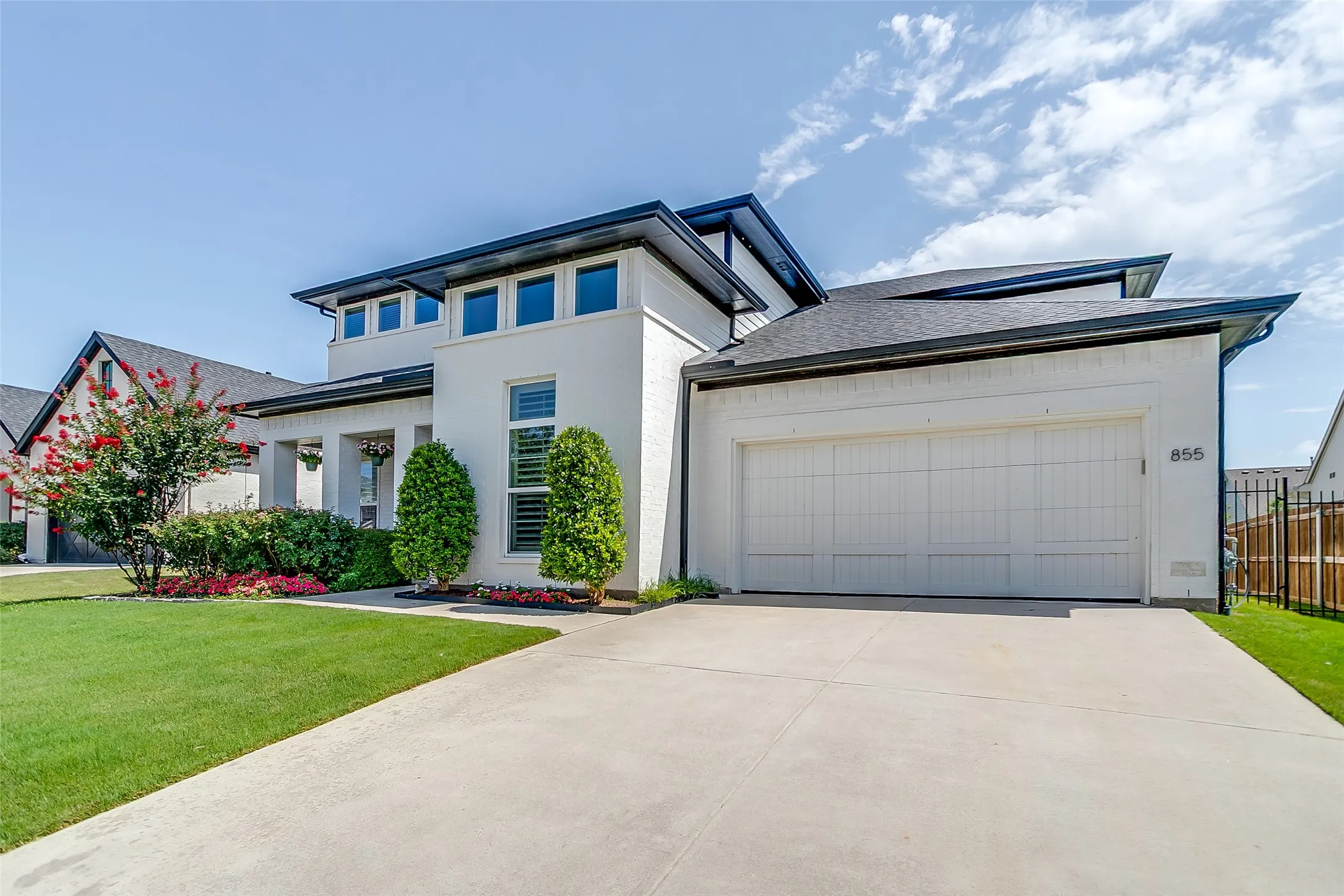 Contemporary white stucco exterior with a black roofline and a two-car garage