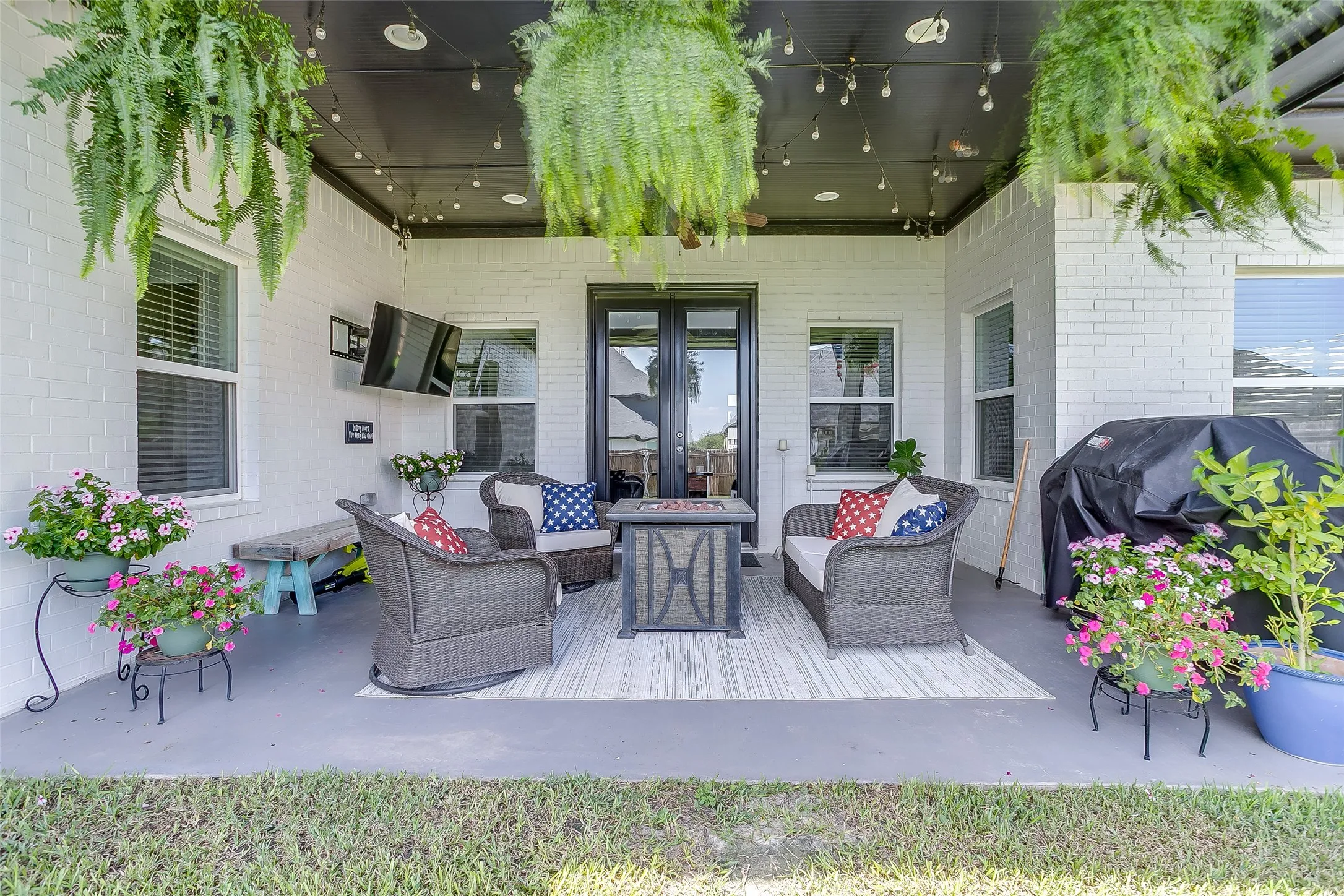 Covered patio featuring a painted brick exterior, dark ceiling, recessed lighting, and a glass-paneled double door entrance